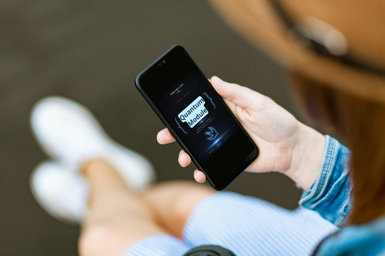 A person holding a black smartphone showing the 'Free Cupcake' app screen, with their legs and white sneakers blurred in the background.